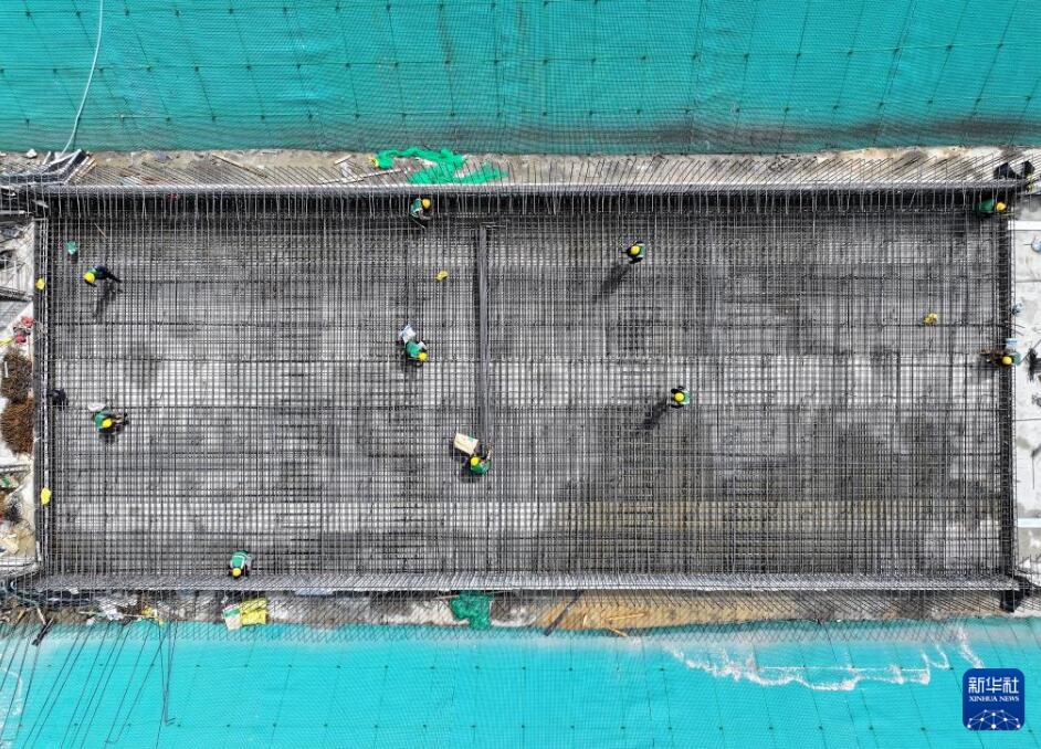 中鉄四局集団公司の作業員が河北雄安新区スタートアップ区のNA12市政道路プロジェクトと総合パイプライン回廊（二期）プロジェクトの建設現場で作業を進める様子（4月23日、ドローンで撮影・牟宇）。