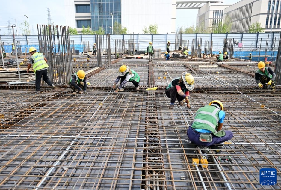 雄安イノベーションセンター二期・三期プロジェクトの建設現場で、鉄筋を束ねる中建三局の作業員（8月21日、ドローンによる撮影・牟宇）。